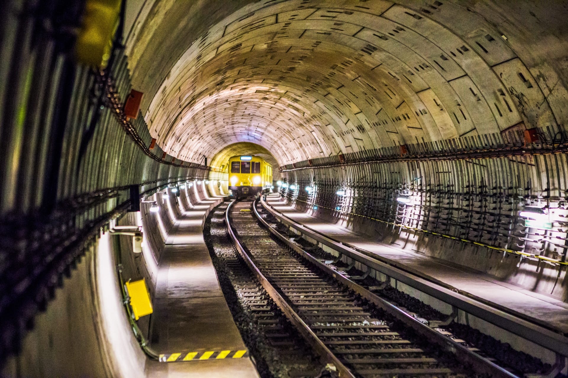 Bilde av t-banens togskinner i en tunnel.