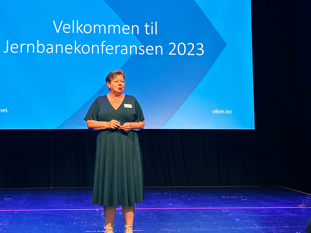 Bilde av Siv Henriette Jacobsen på scenen i Drammen, hvor hun ønsker velkommen til Jernbanekonferansen.
